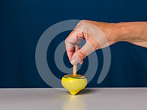 Middle aged woman playing spinning top. Wooden natural toys.