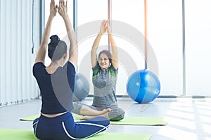 Middle-aged woman practicing yoga in sports club