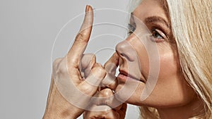 Middle aged woman putting contact lens in her eye