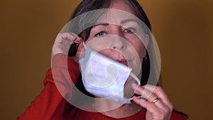 Middle-aged woman putting on face mask for protection against Covid 19 pandemia