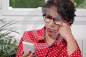 Middle-aged woman reading text message on her mobile phone