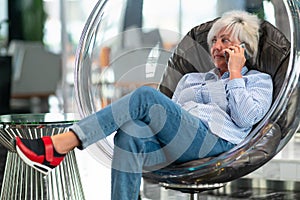 Middle-aged woman relaxing in a comfortable modern tub chair