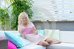 Middle-aged woman relaxing reading at home