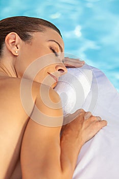 Middle Aged Woman Relaxing Sunbathing By Swimming Pool