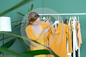 Middle aged woman shopping new dress clothes shelf yellow green blond