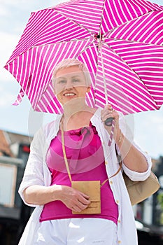 middle-aged woman with a short haircut with an umbrella protecting from sun