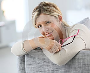 Middle-aged woman sitting on sofa