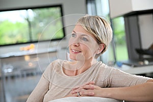 Middle-aged woman sitting on sofa