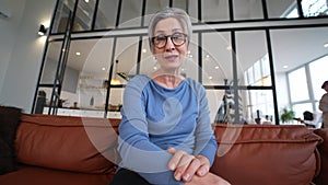 Middle Aged Woman Smiles and Waves to the Camera, talking to the camera.