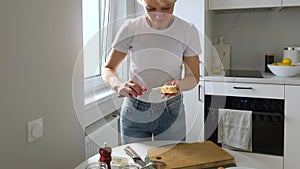 Middle aged woman spreading cream cheese on sandwich