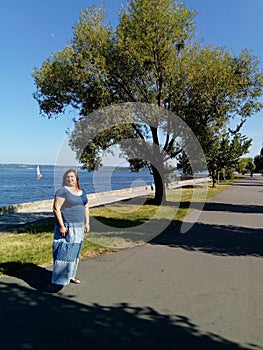 A middle-aged woman is standing on the embankment