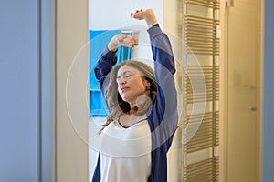 Middle-aged woman stretching with a smile of contentment