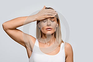 Middle aged woman suffering from terrible strong head pain