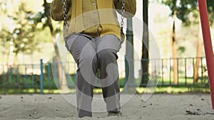 Middle-aged woman swinging, remembering childhood, carefree and happy life