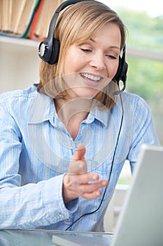 Middle Aged Woman Talking Online Using Headset