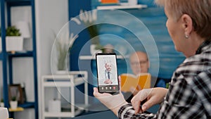 Middle aged woman talking at video conference calling with remote doctor