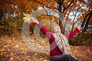 Middle-aged woman throwing leaves in the forest