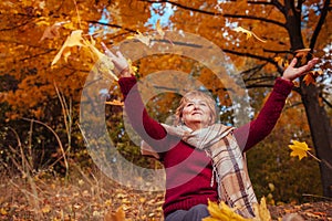 Middle-aged woman throwing leaves in the forest