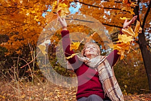 Middle-aged woman throwing leaves in the forest