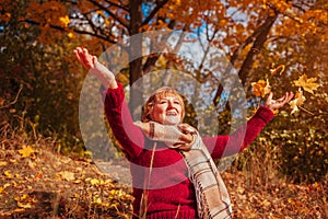 Middle-aged woman throwing leaves in the forest