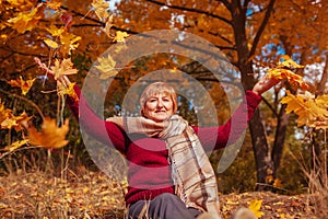 Middle-aged woman throwing leaves in the forest