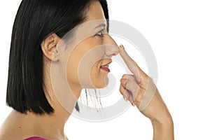 Middle aged woman touches her nose with her finger