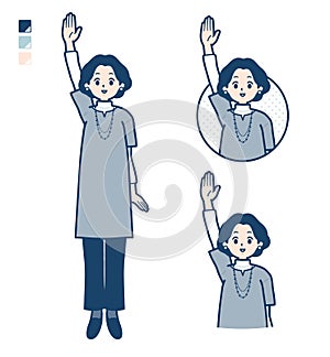 Middle-aged woman in a tunic with raise hand images