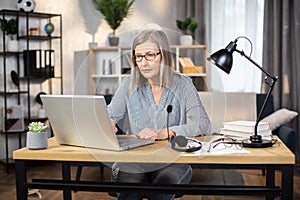 Middle-aged woman typing on computer in home office