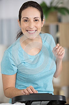 middle aged woman using exercise machine at home