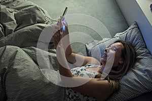 Middle-aged woman using her tablet computer before sleep in bed