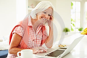 Middle Aged Woman Using Laptop Over Breakfast