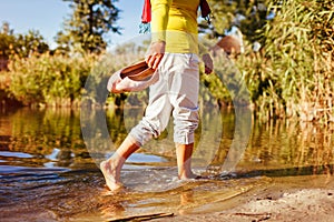 Middle-aged woman walking on river bank on autumn day. Senior lady having fun in the forest enjoying nature. Closeup