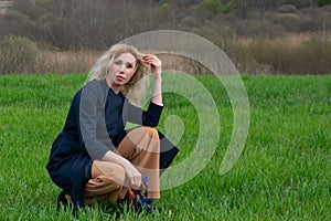 A middle-aged woman walks alone on a dirt road among green fields