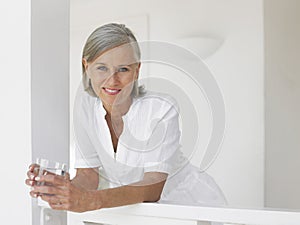 Middle Aged Woman With Water Glass On Verandah photo