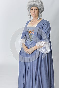 A middle-aged woman wearing an 18th-century robe a la Francaise and a grey wig