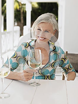 Middle Aged Woman With Wine Glass At Outdoor Table