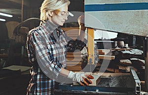 Middle aged woman working with a drill in workshop. Concept of woman in a male-dominated profession, nontraditional gender roles, photo