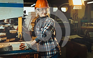 Middle aged woman working with a drill in workshop with copy cpace. Concept of woman in a male-dominated profession,