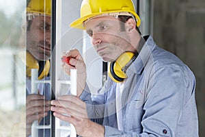 middle-aged workman using screwdriver on door