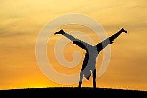 Middle of a cartwheel at sunset.
