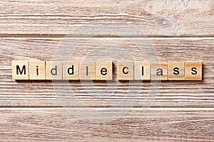Middle class word written on wood block. Middle class text on table, concept