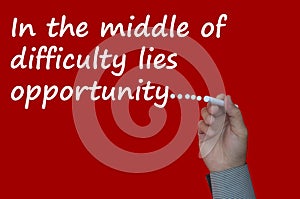 In the middle of difficulty lies opportunity text on red cover background.