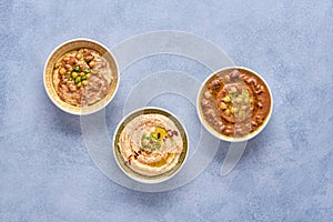 Middle eastern, arabic traditional chickpea dishes hummus, foul,  and qudsia. Top view with copy space