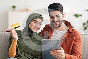 Middle Eastern Couple Shopping Online Using Digital Tablet At Home