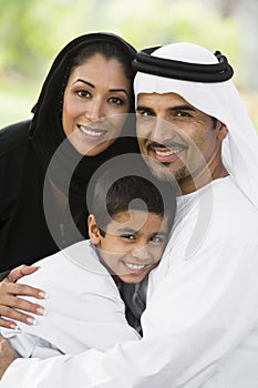 A Middle Eastern couple and their son in a park