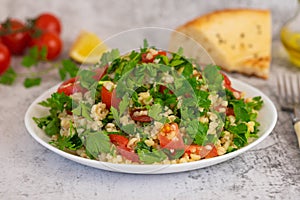 Middle Eastern cuisine. Vegetarian salad with bulgur, vegetables. Fresh bright arabic salad. Tabbouleh salad