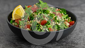 Middle Eastern cuisine. Vegetarian salad with bulgur, vegetables. Fresh bright arabic salad. Tabbouleh salad