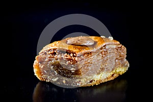 Middle Eastern dessert called mabroume or bahlava isolated on black background photo