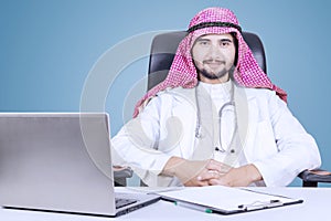Middle eastern doctor with laptop on desk