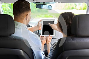 Middle-eastern family having car trip, using mobile app on pad